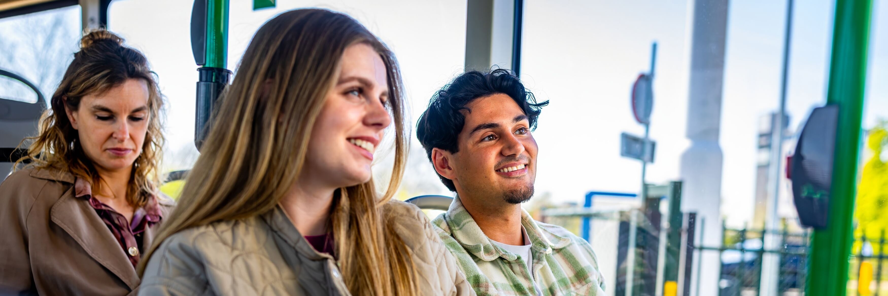 Drie  jonge reizigers zitten in een bus