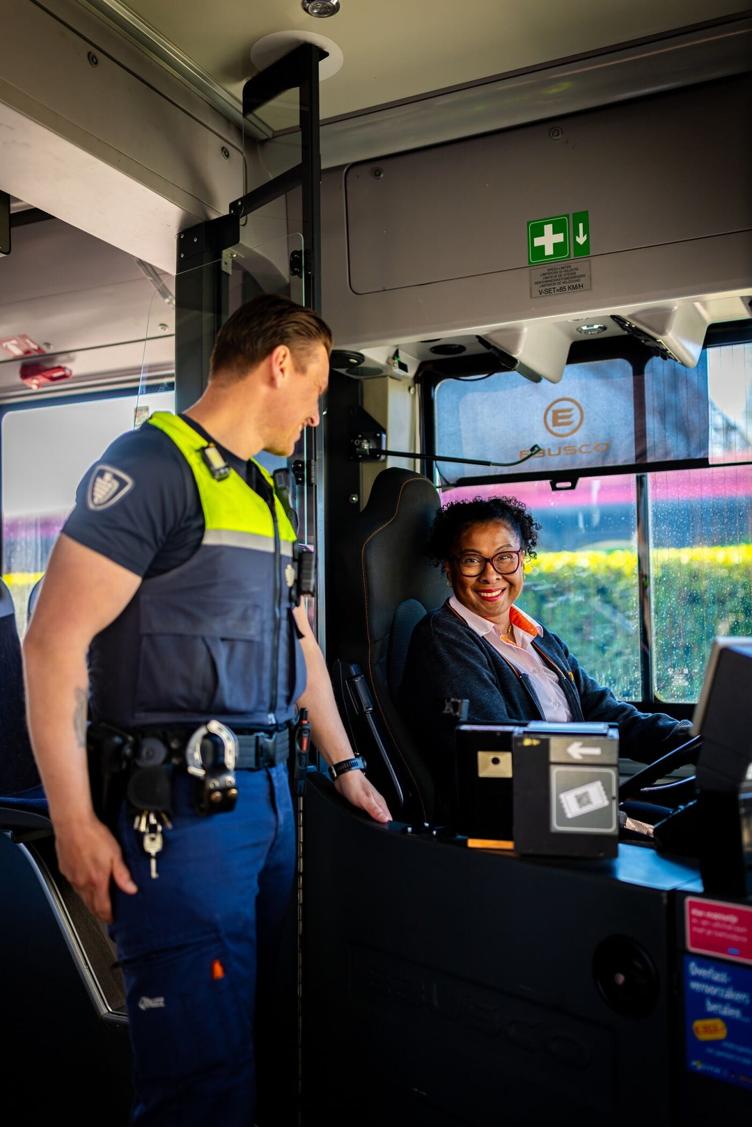 Service en veiligheid medewerker en buschauffeuse kijken naar elkaar