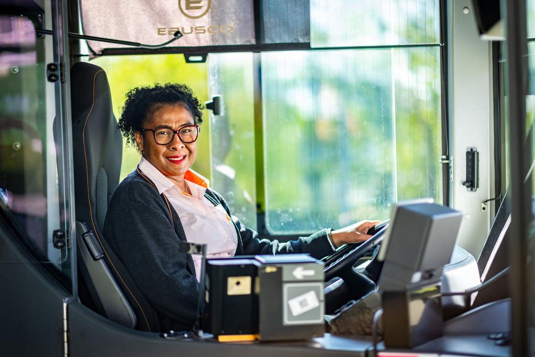 Lachende chauffeuse in de bus
