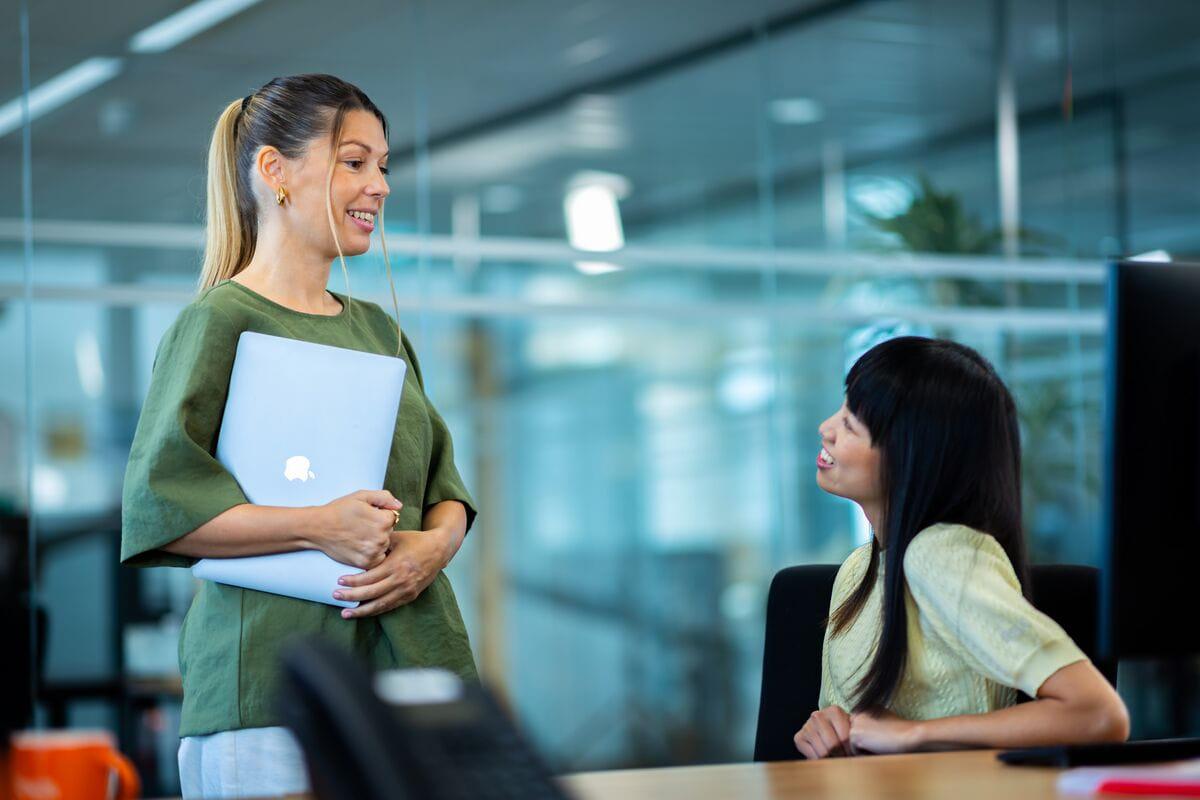 Twee Qbuzz collega's praten met elkaar op kantoor