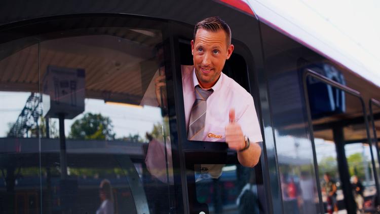Trein machinist kijkt steekt zijn hoofd uit het raam en steekt zijn duim omhoog